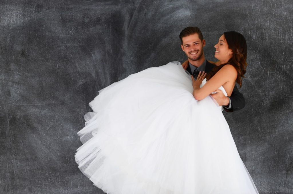 groom carrying the bride while they laugh together